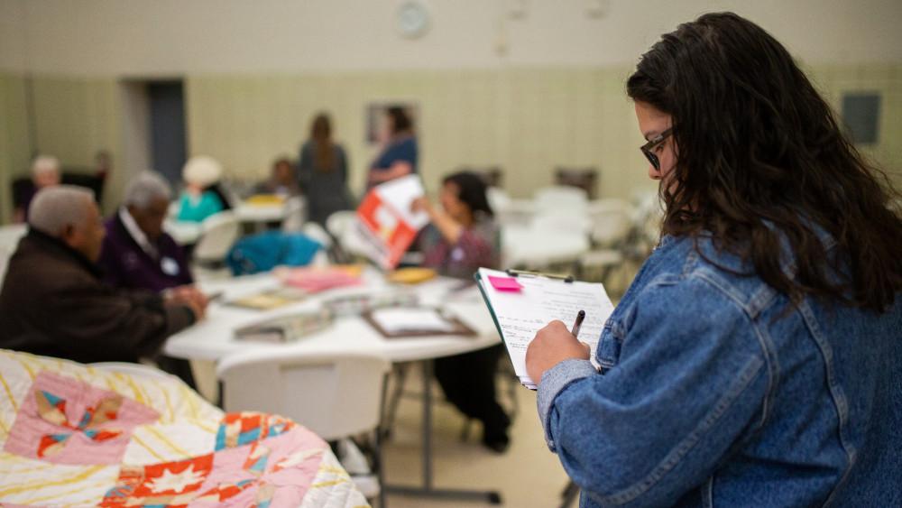 Bre Partida-Castillo'20 makes notes about a pinwheel quilt the Edmond-Elzy family brought to the ...