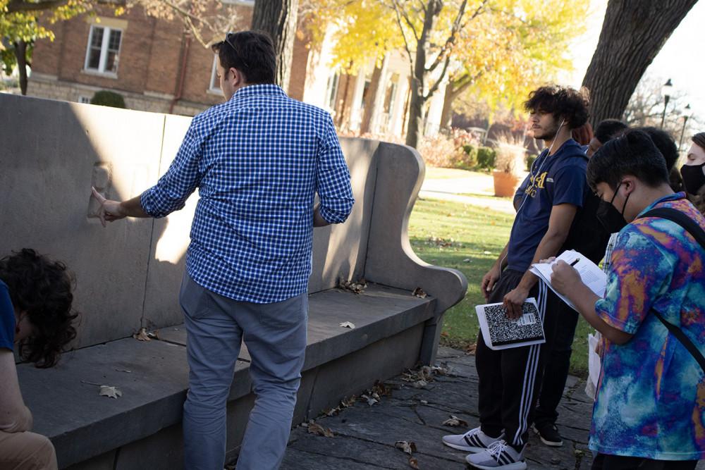 Geology professor Jay Zambito talks with students about a limestone bench on campus.
