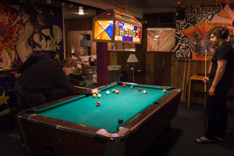 Students play a game of pool in the C-Haus, circa 2015.